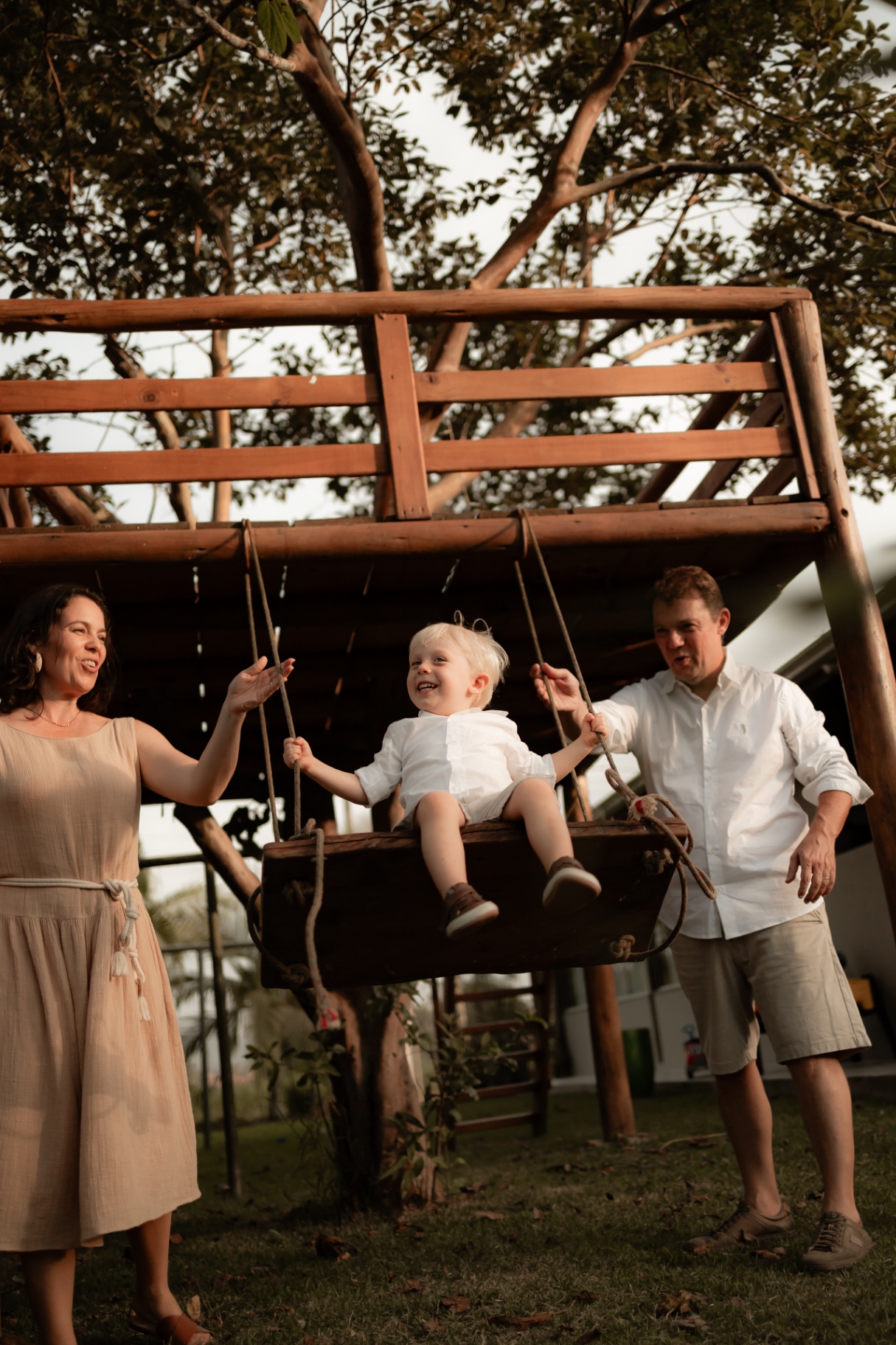 Família no balanço ao entardecer