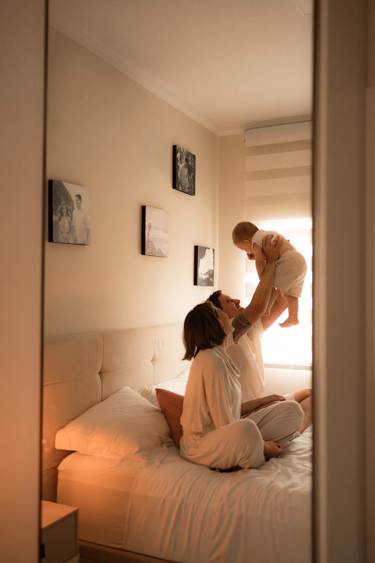 Pais brincando com o bebê no quarto